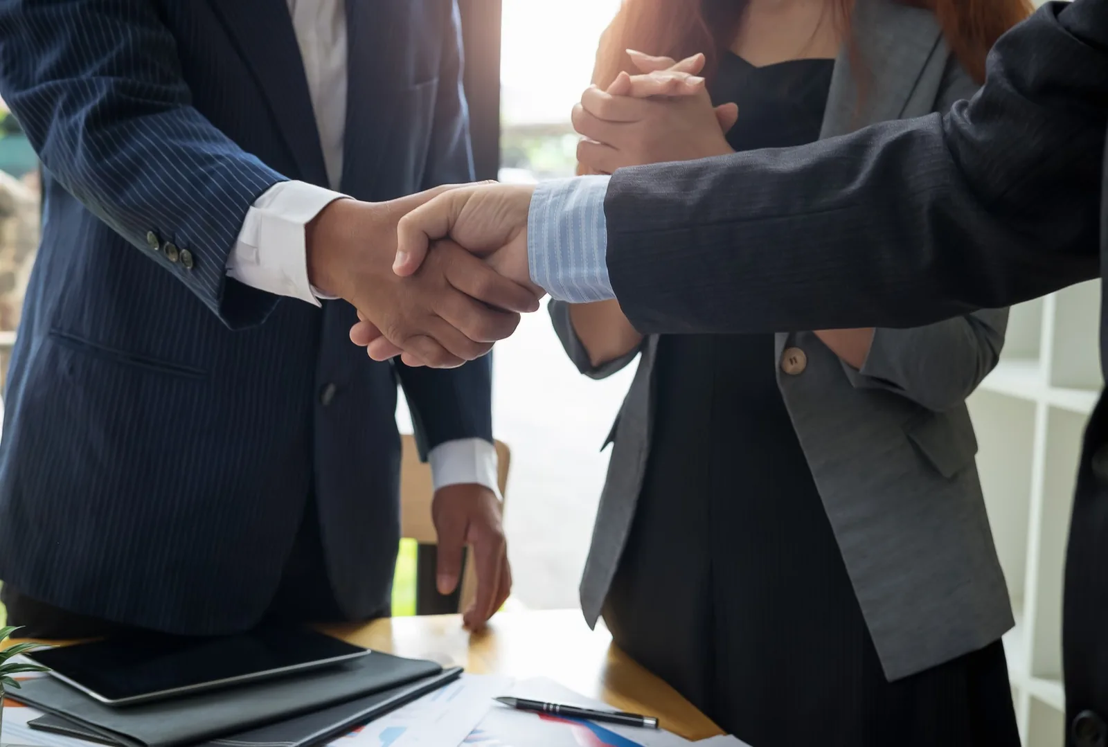 Profesionales estrechando las manos durante una reunión de trabajo